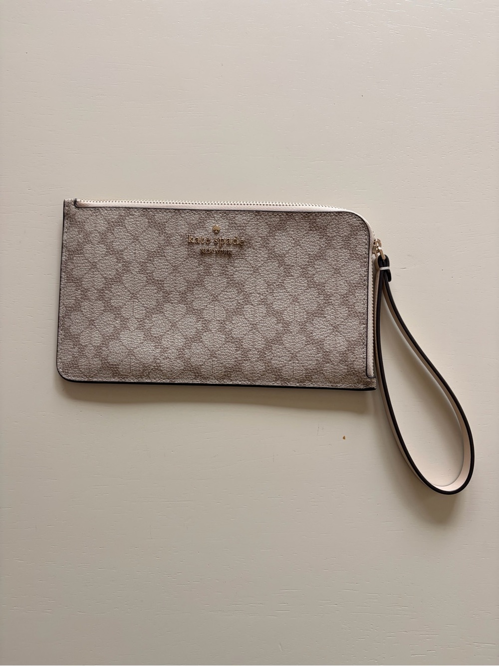 kate spade cream patterned wristlet clutch with gold logo